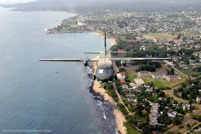 O C-212-100 AVIOCAR a sobrevoar a avenida marginal da cidade de S. Tomé