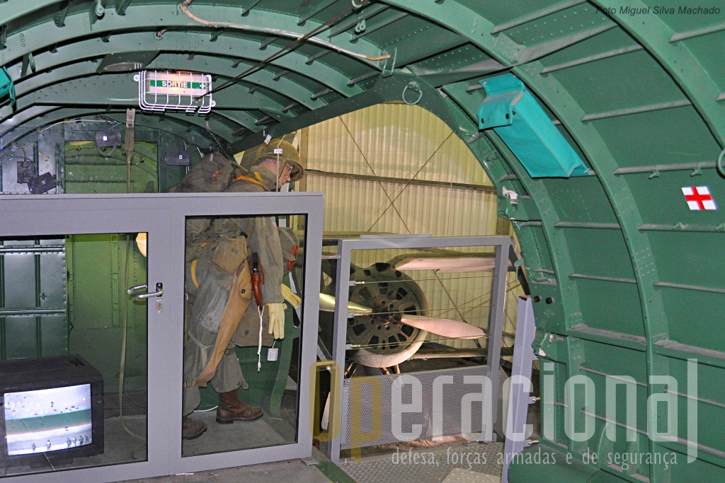 Interior do Douglas C-47 Skytrain / Dakota, com uma adaptação para apresentar um pára-quedista americano a salta sobre a Normandia, com um monior de TV apresentando filmes da época. Em fundo um Policarpov I-153 Tchaika.