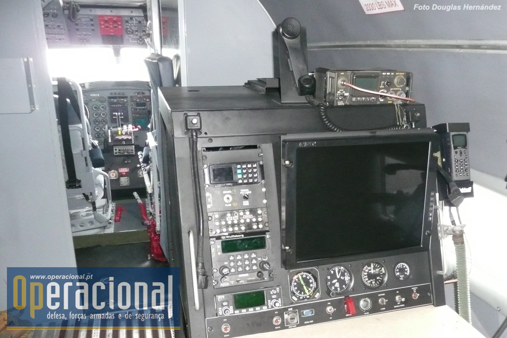 A consola designada "estação de inteligência", vendo-se a tela para apresentação do FLIR e vários tipos de equipamento de rádio para comunicação ar-ar, ar-terra e varrimento do espectro de frequências. As imagens do FLIR podem ser transmitidas em tempo real aos centros de Comando e Controle da Força Aérea Colombiana.