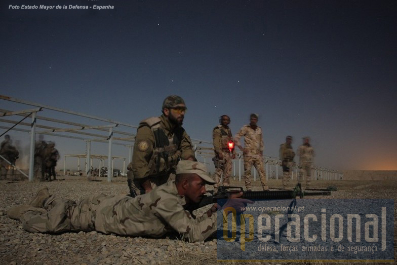 Foto Estado_Maior de Defesa de Espanha com a seguinte legenda: Instructor portugués al lado del soldado iraquí, a quien supervisa su ejercicio de fuego real nocturno con M16.